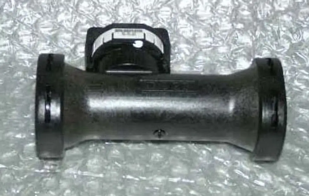 Flowmeter von Remeha, in schwarzer Kunststoffausführung mit einer runden Form und einem angebrachten Montagesystem, auf schützendem Material platziert.